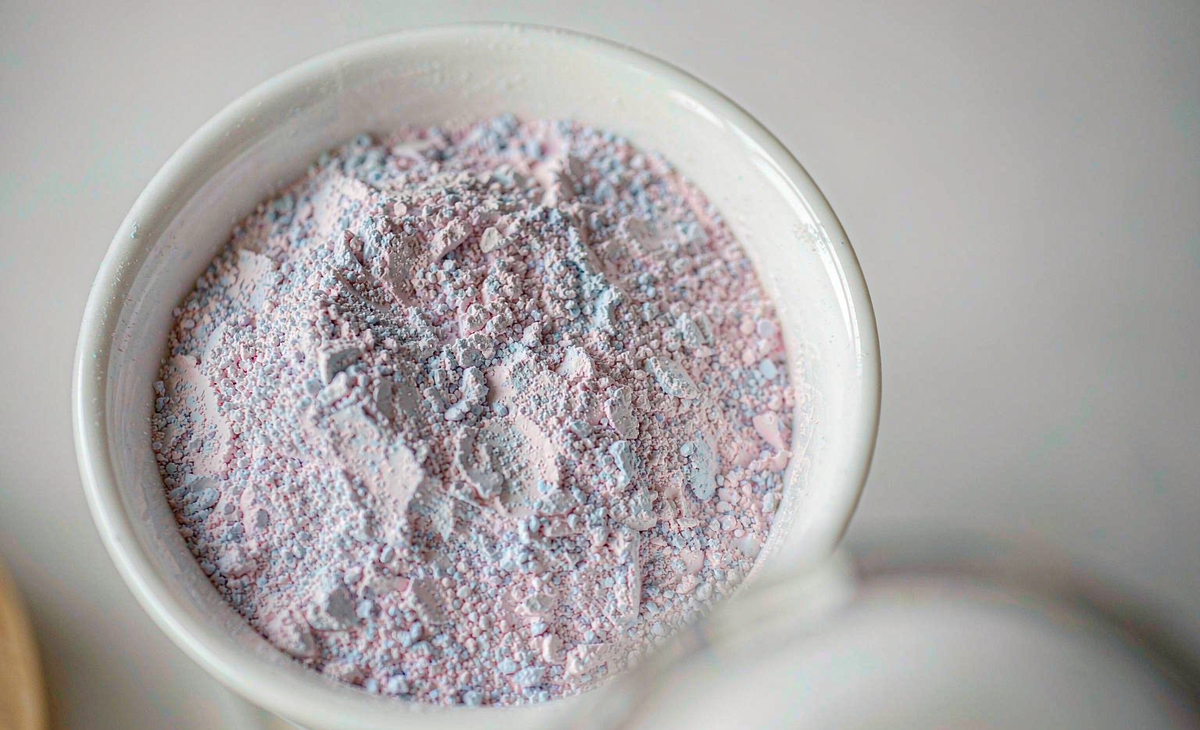Matte dry cosmetic-grade pearl pigment powder in a white studio dish — mica-based pearlescent pigment for makeup applications